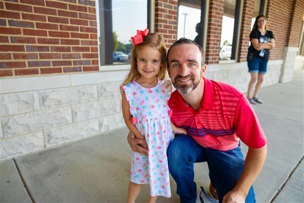 a dad and girl student smiling in front of CCES